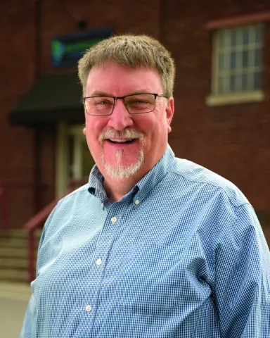 Gary Harvey outside in front of brick wall