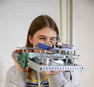 A student holding a robot