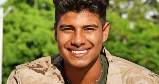 Man in military fatigues smiling at the camera