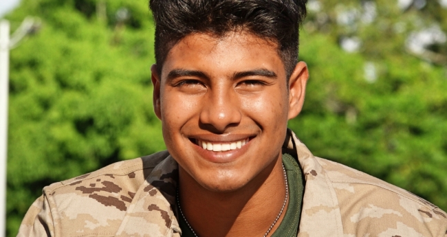 Man in military fatigues smiling at the camera